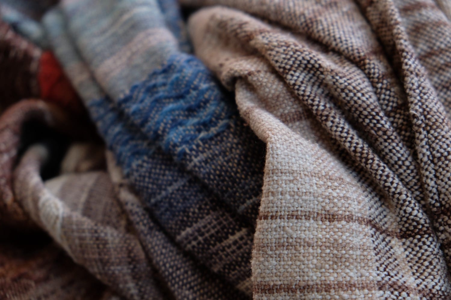 A length of handwoven fabric with details of fluid rainbows, a blue illuminated river and snowflakes