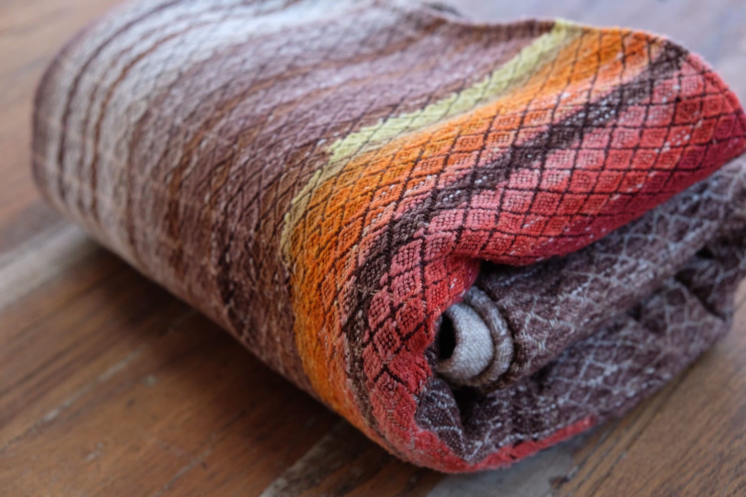 A length of handwoven fabric with details of fluid rainbows, a blue illuminated river and snowflakes