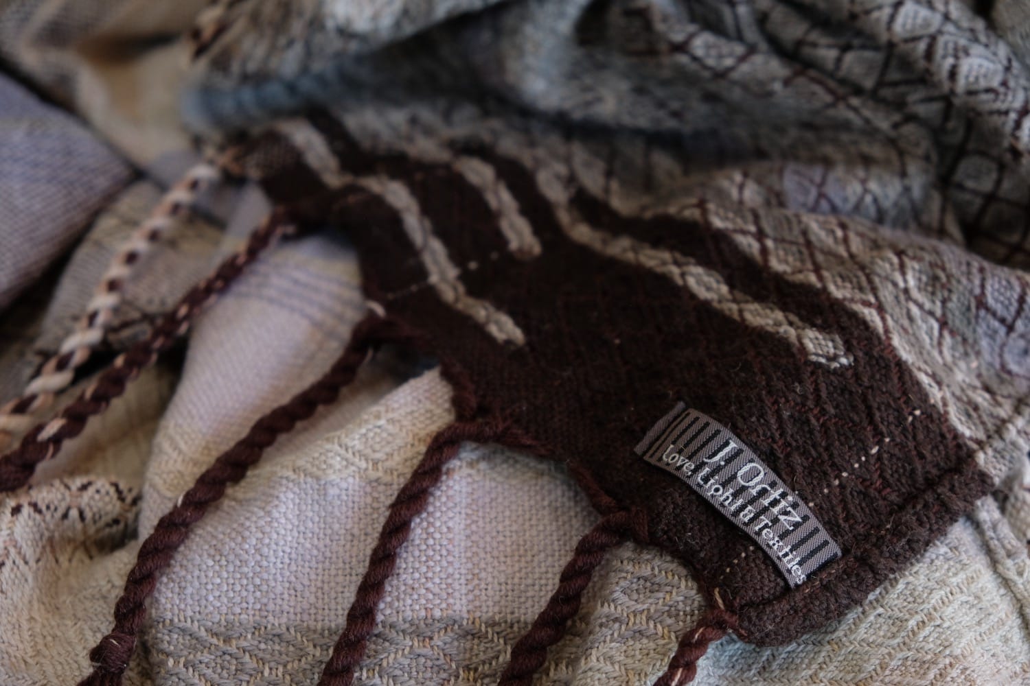 A detail of naturally dyed handwoven fabric in moody shades of gray, misty blue and black with a white moon in the middle and cloud designs throughout