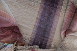 Highly textured handwoven fabric that is white, purple and pink