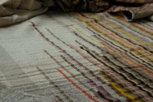handwoven raw silk fabric with softly colored lines woven into it in browns, red, yellow, pink