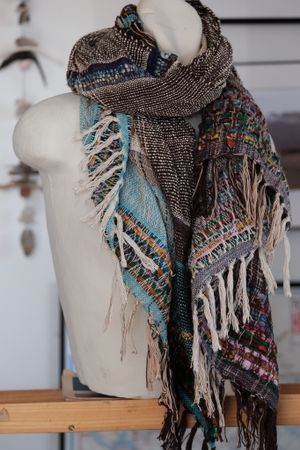 Multicolored and highly textured scarf on a white mannequin 