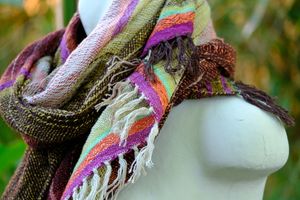 Handwoven brightly colored pink, orange, teal and chartreuse scarf on a white mannequin