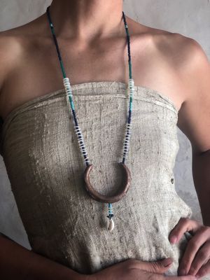 woman wearing  copper crescent moon necklace with blue beads 
