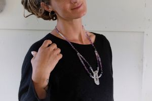 Woman wearing Clear quartz point, rose quartz, blue chalcedony, purple fluorite and labradorite necklace