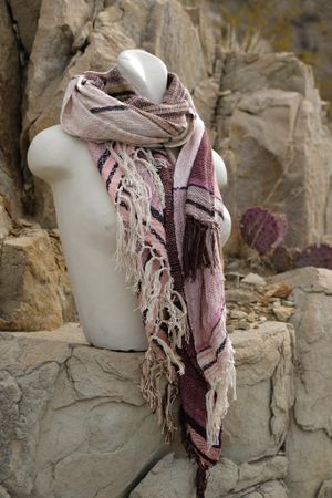 pink, black and white cotton and silks scarf with fringe on a white mannequin bust in the desert