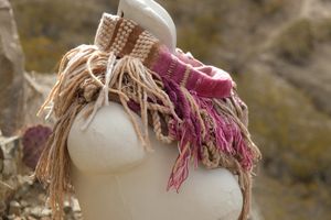 naturally dyed brown, fuchsia and tan fringed infinity scarf on a white mannequin bust in the desert