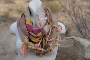 naturally dyed brown, white, pink, salmon, yellow and green highly textured scarf on a white mannequin bust in the desert