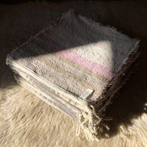 Detail of a stack of handwoven pink, white and brown slubby linen-cotton washcloths