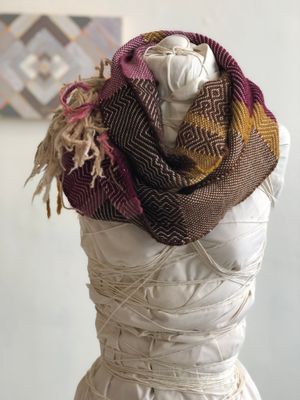 brown, yellow, tan and raspberry handwoven cowl scarf with fringe on a white mannequin in a white walled gallery
