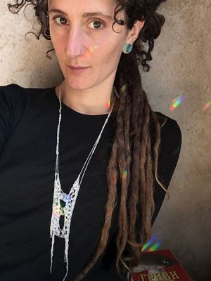 woman in a black shirt wearing a necklace made of silver chain