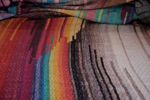 handwoven raw silk fabric woven with a diamond pattern in rainbow, gray, brown and cream colors
