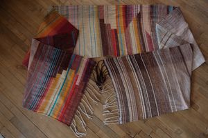 Handwoven fabric with a diamond texture pattern in natural browns, grey, purples, reds, turquoise, yellow, orange and pink.