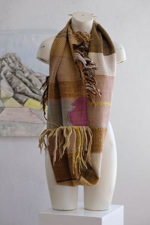 A white painted mannequin torso wears a handwoven naturally dyed highly textures loop scarf